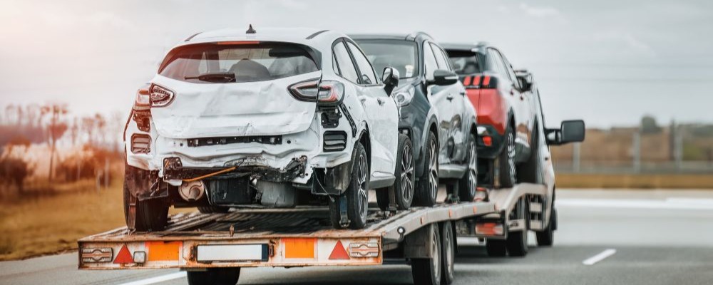 運送業グループへのM&Aによる整備内製化をイメージした、積載車（キャリアカー）で搬送される自動車