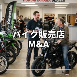 バイク販売店の店舗内で、スタッフがお客様に車両の説明をしている自然な営業風景の様子。