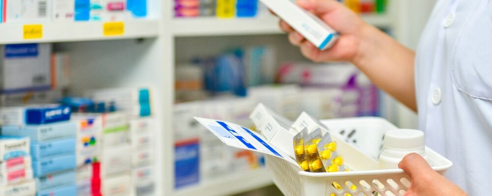調剤薬局のM&A事例を紹介する、カウンターで薬剤師から薬を受け取るイメージ画像