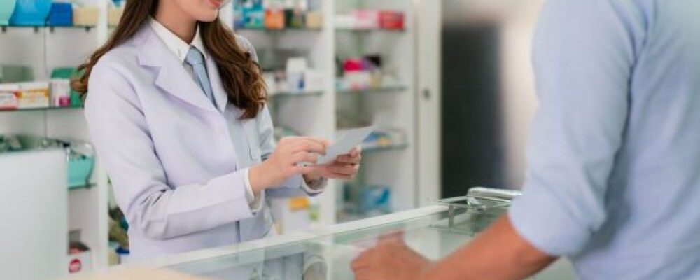 白衣を着た女性薬剤師とM&Aコンサルタントが笑顔で面談・相談を行っているイメージ画像